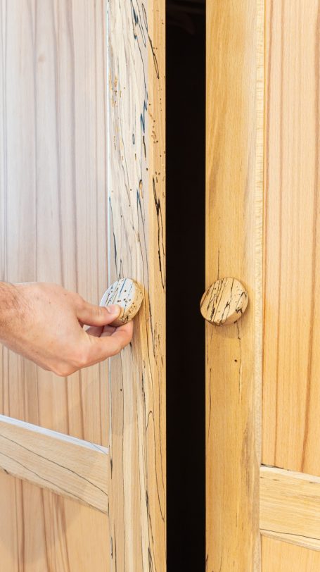 Hölzerne Schranktür wird geöffnet, mit einer handgefertigten Knauf aus Holz.