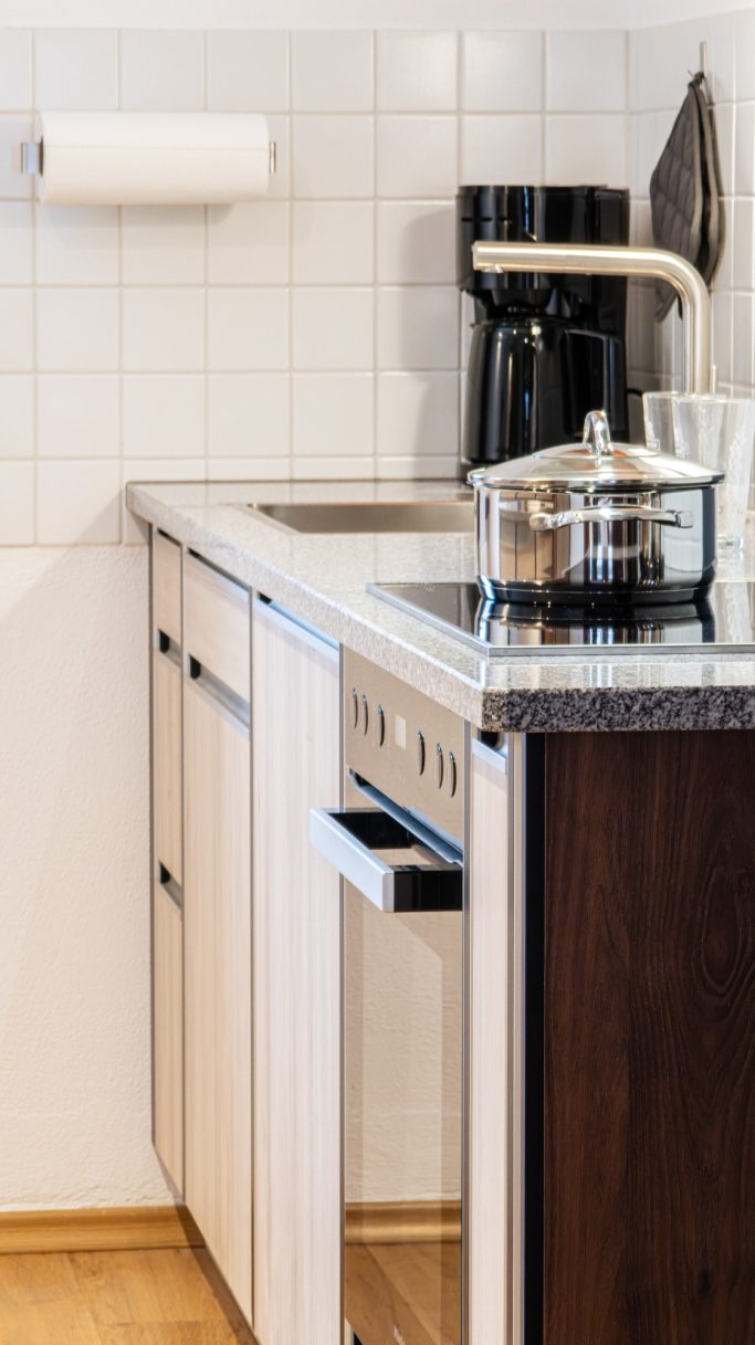Moderne Küche mit Kaffeemaschine, offenem Schublade und eleganter Arbeitsplatte.