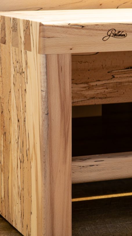 Holztisch mit natürlicher Maserung und einer markanten Kante.
