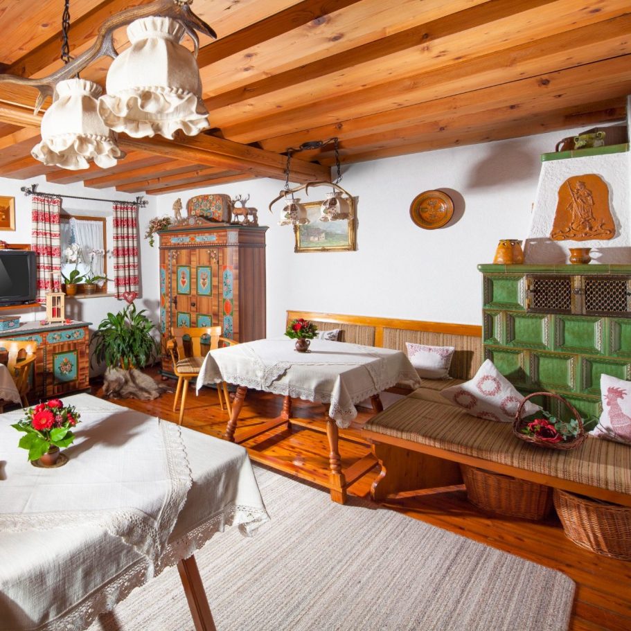 Gemütliche, rustikale Stube mit Holzmöbeln und Blumendekoration.