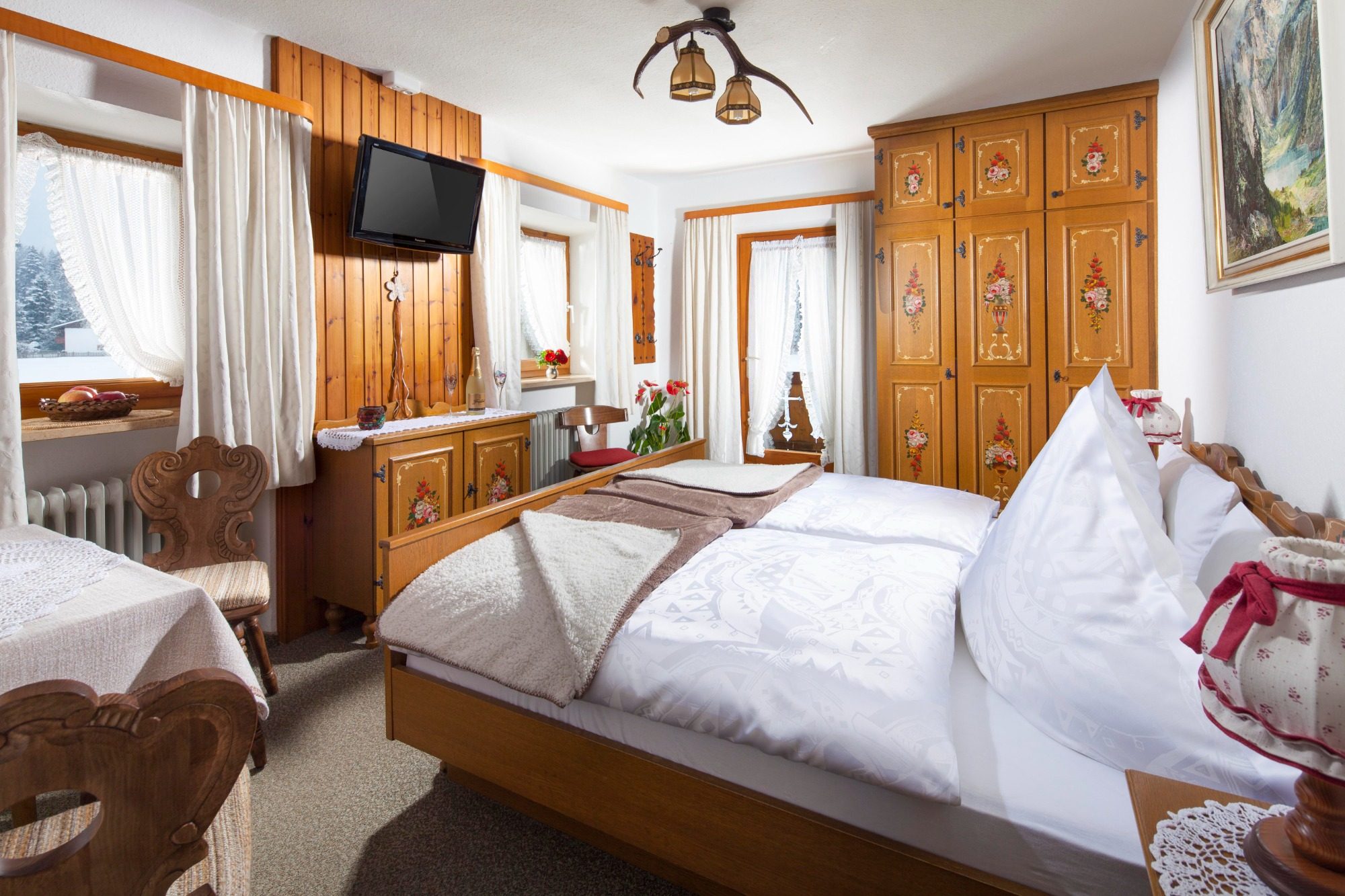 Helles, gemütliches Schlafzimmer mit Doppelbett und rustikalem Holzinterieur.