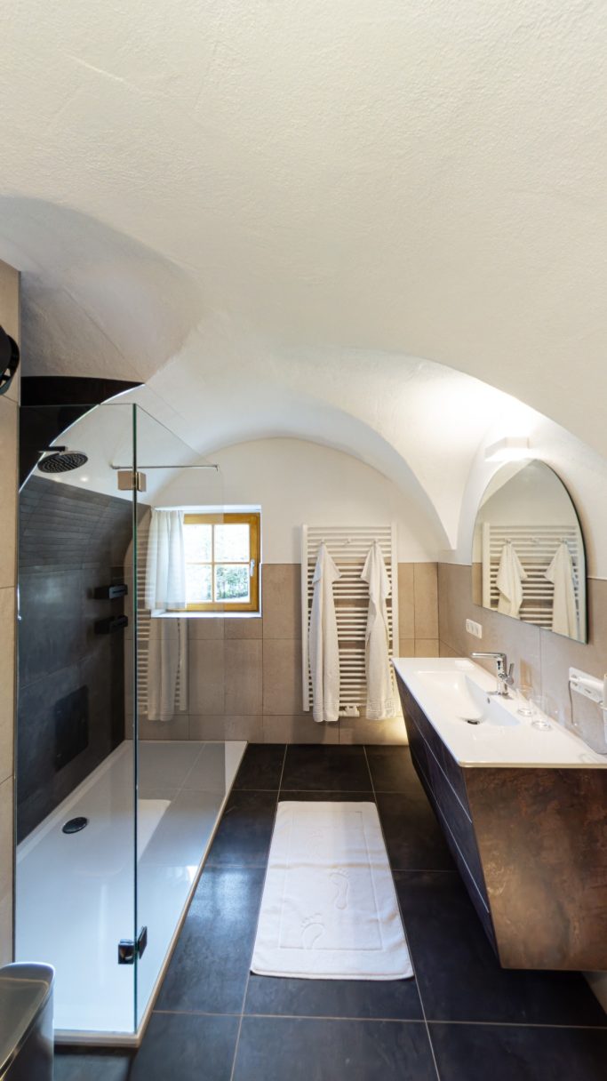 Helles modernes Badezimmer mit Dusche, Waschbecken und großzügigem Spiegel.